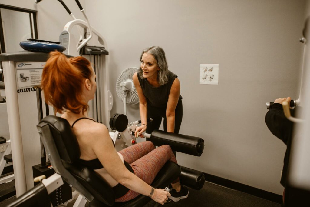 A personal trainer guiding women during a workout session in a gym setting.