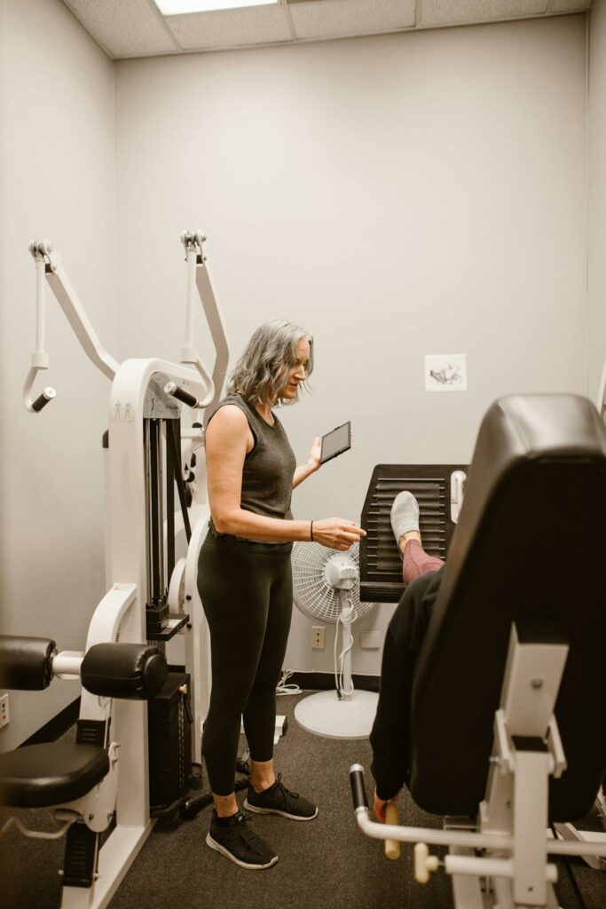 Woman guiding another in gym for health and wellness support.