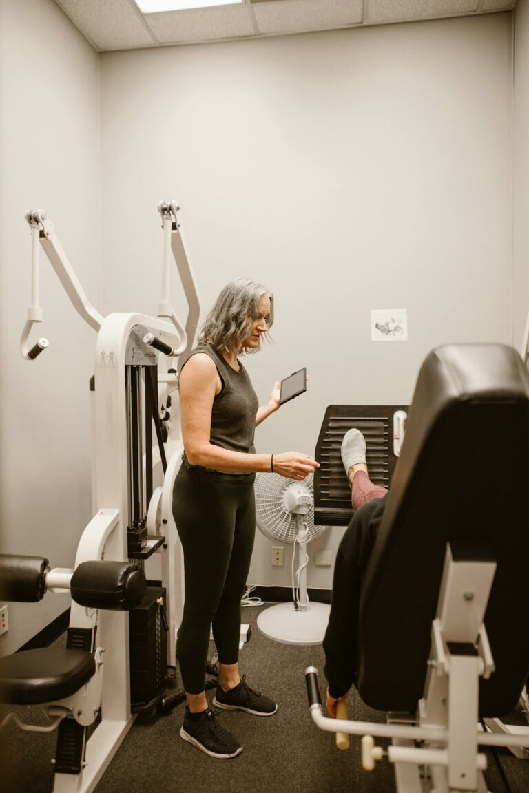 Woman guiding another in gym for health and wellness support.